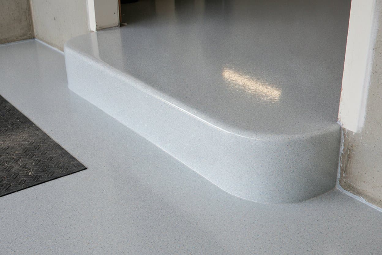 Polyaspartic topcoat wrapping a garage step edge